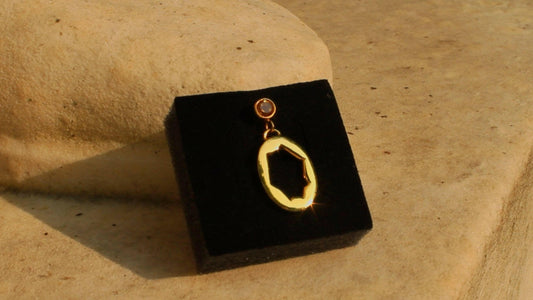 Ricochet Earring in solid .925 silver with 24kt gold plating and citrine stone, displayed on a black velvet background.